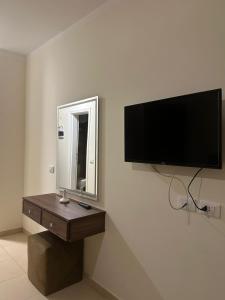 een flatscreen-tv aan een muur met een spiegel bij Traveller Namma bay in Sharm El Sheikh +21 foto's