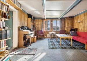 a living room with a red couch and a table at Lofoten Farm House in Vestvågøya
