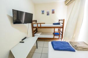 a small room with a tv and a bed at Pousada Espaço Viagi in Taubaté