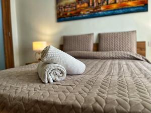 a rolled up towel sitting on top of a bed at Charming Two Bedroom Apartment in Tal-Pietà +7 photos