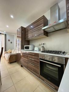 a kitchen with a stove and a microwave at Charming Two Bedroom Apartment in Tal-Pietà