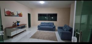 a living room with two blue couches and a tv at Ilhéus Bahia beach houseia in Ilhéus