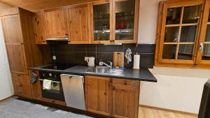 a kitchen with wooden cabinets and a sink at Mayen La Grangette, bulle d'évasion in Nendaz