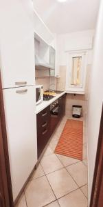 una cucina con frigorifero bianco e pavimento piastrellato di Casa Vacanze-Trieste San Giusto a Trieste
