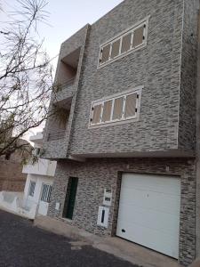 a large brick house with a garage at L&E Apartment in Mindelo
