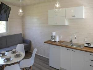 eine Küche mit Spüle, Tisch und Couch in der Unterkunft Bungalow in Kolczewo near Baltic Sea Beach in Kołczewo
