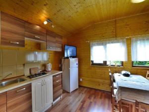 a kitchen with a white refrigerator and a table at Cottage in Rusinowo near Seaside Beach in Rusinowo +18 photos
