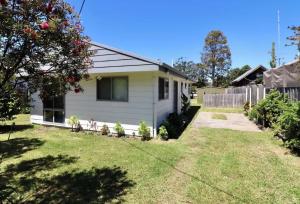 a white house with a fence and a yard at 36 Betka Road in Mallacoota