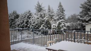 a balcony with a table and snow covered trees at Las Damas casa rural in Avila