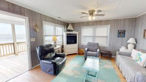 a living room with a couch and a tv at Fooses Folly in Folly Beach