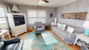 a living room with a couch and a tv at Fooses Folly in Folly Beach