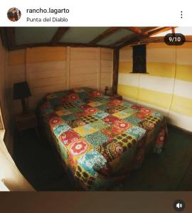 a bed in a room with a quilt on it at Rancho lagarto in Punta Del Diablo