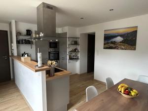 cocina y comedor con una mesa con un bol de fruta en L'écureuil des lacs, en Xonrupt-Longemer