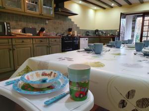 a kitchen with a table with a table cloth on it at Maison de l'olivier in Champniers-et-Reilhac
