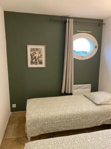 a bedroom with a bed and a window at Au pied des Alpilles in Paradou