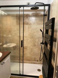 a shower with a glass door in a bathroom at Au pied des Alpilles in Paradou