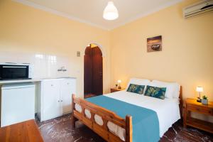 1 dormitorio con 1 cama azul y blanca y cocina en Levante Studios, en Benitses