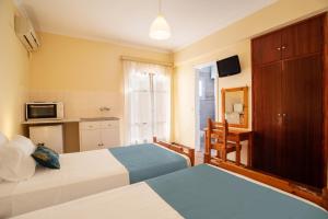 Una habitación de hotel con dos camas y cocina. en Levante Studios, en Benitses