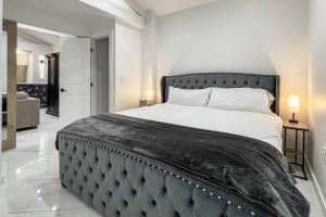 a bedroom with a large bed with a black headboard at Cozy Cottage in Cos Cob in Greenwich