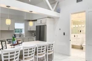 a white kitchen with a white table and chairs at Cozy Cottage in Cos Cob in Greenwich