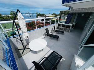 a balcony with a table and chairs on a building at Duplex Cobertura com hidro in Bertioga