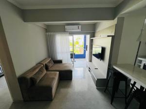 a living room with a couch and a table at Duplex Cobertura com hidro in Bertioga