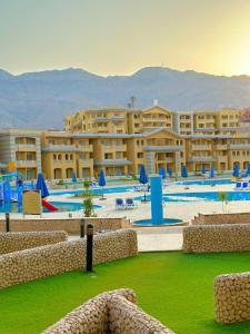 a resort with a swimming pool with blue umbrellas at بورتو السخنه اكوا بارك in Ain Sokhna