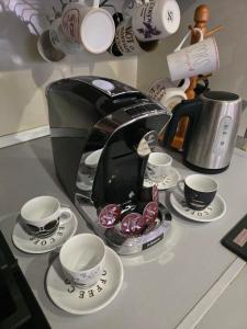 a coffee maker and cups and saucers on a counter at Petra's Skyline in Suceava