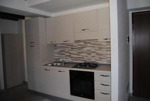 a kitchen with white cabinets and a sink and a stove at Casa da Giorgia in Lezzeno