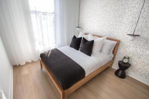 Un dormitorio con una cama con almohadas blancas y negras. en Studio #1 - Self Check-In - Plateau - St-Denis, en Montreal