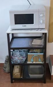 a microwave sitting on top of a shelf with food at 10 da Muralha in Estremoz