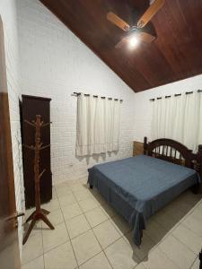 a bedroom with a bed and a ceiling fan at Aconchego em Gravatá! Temporada in Gravatá