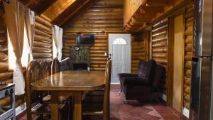 a dining room in a log cabin with a table and chairs at Cabañas Rincon del Ángel 2 in Ciénaga