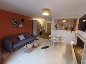 a living room with a blue couch and a table at Terracotta in Sainte-Livrade-sur-Lot