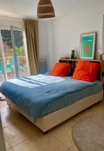 a bed with orange and blue sheets in a bedroom at Piscine chauffée, tennis, Mas provençal contemporain in Draguignan +30 photos