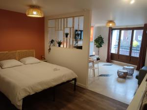 a bedroom with a bed and a dining room with a table at Terracotta in Sainte-Livrade-sur-Lot