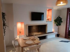a living room with a table and a fireplace at Terracotta in Sainte-Livrade-sur-Lot