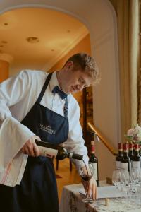 Ein Mann in einer Schürze schenkt ein Glas Wein ein. in der Unterkunft Oranmore in Ballymena + 94 Fotos