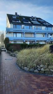 a large blue building with grass in front of it at Seetempel 19 - direkt am Strand ,Hunde willkommen in Scharbeutz