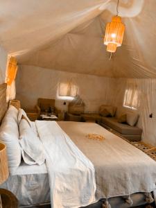 a bedroom with a large bed and a couch at Merzouga Luxurious Sahara Camps in Merzouga