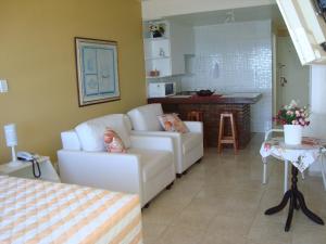 a living room with a couch and a table at Farol Barra Flat 202 in Salvador