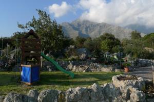 a green slide in a garden with mountains in the background at Pensione Campese in Formia