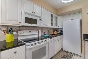 a kitchen with white cabinets and a white refrigerator at Sands Beach Club 922 in Myrtle Beach