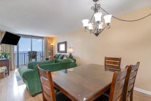a dining room and living room with a table and a couch at Sands Beach Club 922 in Myrtle Beach
