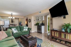 a living room with green furniture and a flat screen tv at Sands Beach Club 922 in Myrtle Beach