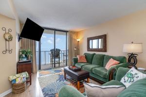 a living room with a green couch and a balcony at Sands Beach Club 922 in Myrtle Beach +27 photos