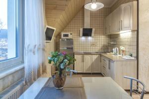 a kitchen with a table with a vase of flowers on it at FAVAR Carpathians in Skhidnitsa