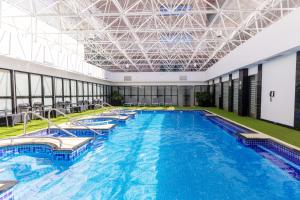 a large pool with blue water in a building at Barceló Mexico Reforma in Mexico City
