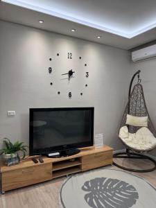 Una sala de estar con un televisor de pantalla plana en una pared. en Hanna Apartment, en Tirana