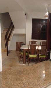 a dining room with a table and chairs and a staircase at Paraíso de Maracajaú in Maxaranguape